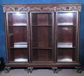 Lot 004 - Antique Carved Three-Door Glass-Front Bookcase with Green Man Masks, Rope-Twist Columns, and Claw-And-Ball Feet, 74" L x 66-3/4" H