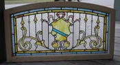 Antique arched stained glass window with jewel