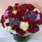 99 Red roses, 35 purple and white hydrangea arranged  in large clear glass vase. W999