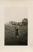 WOMAN HOLDING BOX CAMERA.