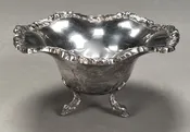 LOT 002 –  MEXICAN STERLING SILVER FOOTED BOWL WITH SCROLL WORKED SHAPED RIM AND BIRD HEAD FEET MARKED “PLATERIA ALAMEDA, JUAREZ”.  4″(H), 6-3/4″(D), 16.9 OZT