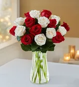 2 dozen white and red roses in a vase with greenery