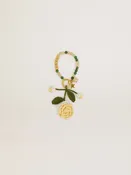 Gelber Charm in Rosenform aus gehäkelter Baumwolle mit Perlenkettchen