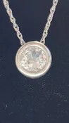 0.50ct clear star brilliant cut Texas topaz is back-set in a sterling silver slide pendant and chain.