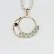 Circular Mixed Metals Pendant with a Sapphire