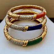 A set of three engraved gold, diamond, and gemstone bangles by Van Cleef & Arpels France.