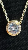 1.45 ct clear star brilliant cut Texas topaz is set in a 14kt gold bezel slide pendent on a gold chain.