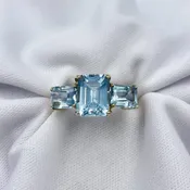 10k Yellow Gold Emerald Cut Blue Topaz Three Stone Ring | Warren Jewelers
