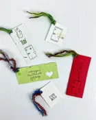 A set of three hand-stamped plantable paper gift tags with festive yarn ties. — PAPERCRAFT MIRACLES LLC